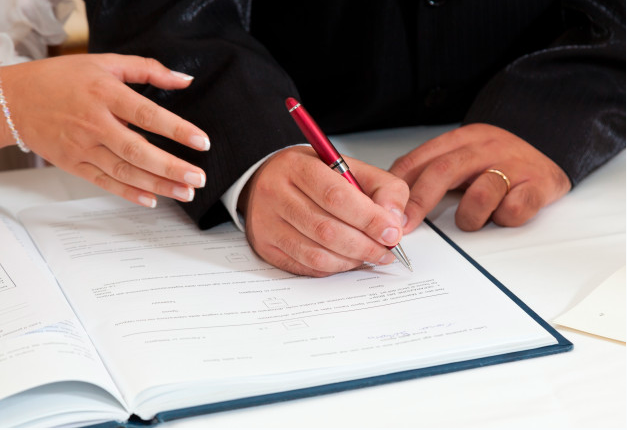 Noivos assinando certidão de casamento